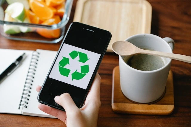 Smartphone displaying a recycling symbol as a reminder of sustainable living