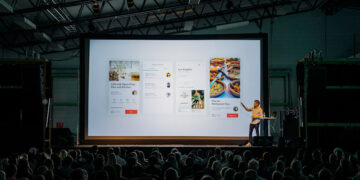 technology seminar presenter speaking to audience at tech conference event