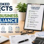 Professional office workspace showing a small business compliance checklist, tax documents, 1099 forms, W-9 paperwork, calculator, and business records for regulatory compliance.