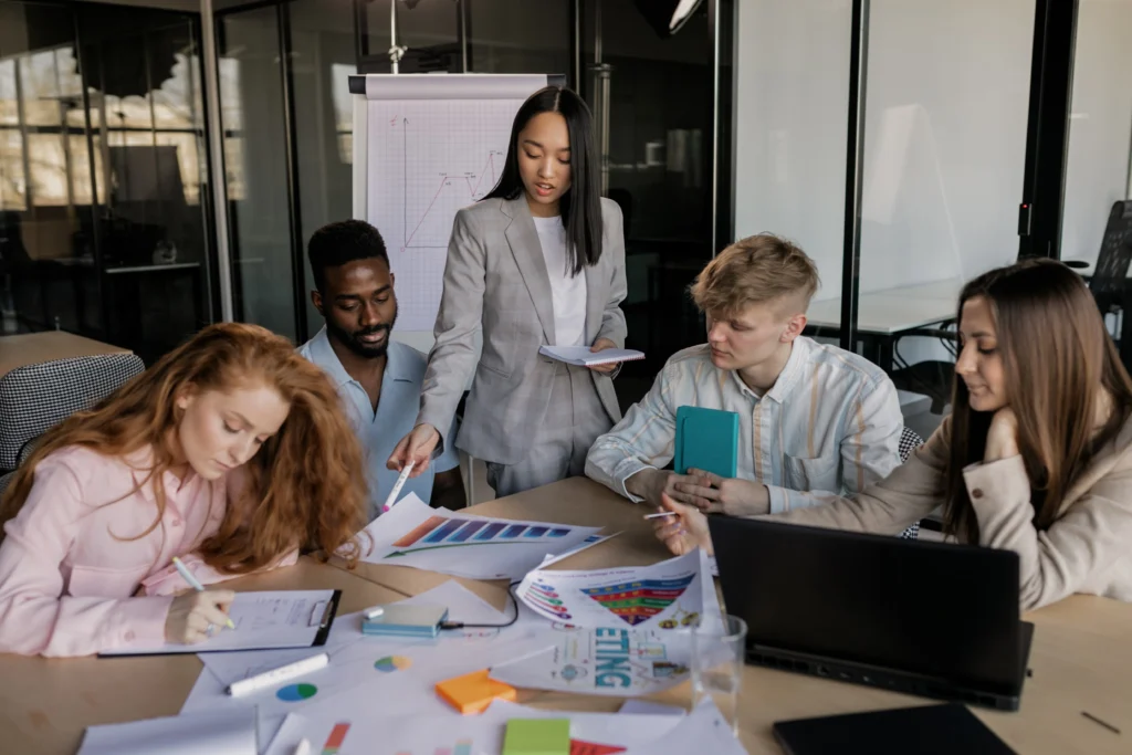 Small business owner reviewing a compliance checklist with tax documents, 1099 forms, worker classification records, and financial reports to stay compliant with business regulations.