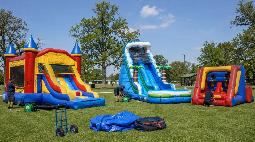 Commercial bounce house, water slide, and inflatable game equipment set up for a party rental event