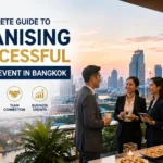 Business professionals networking at a rooftop corporate event in Bangkok with the city skyline, luxury venue, and modern conference atmosphere.