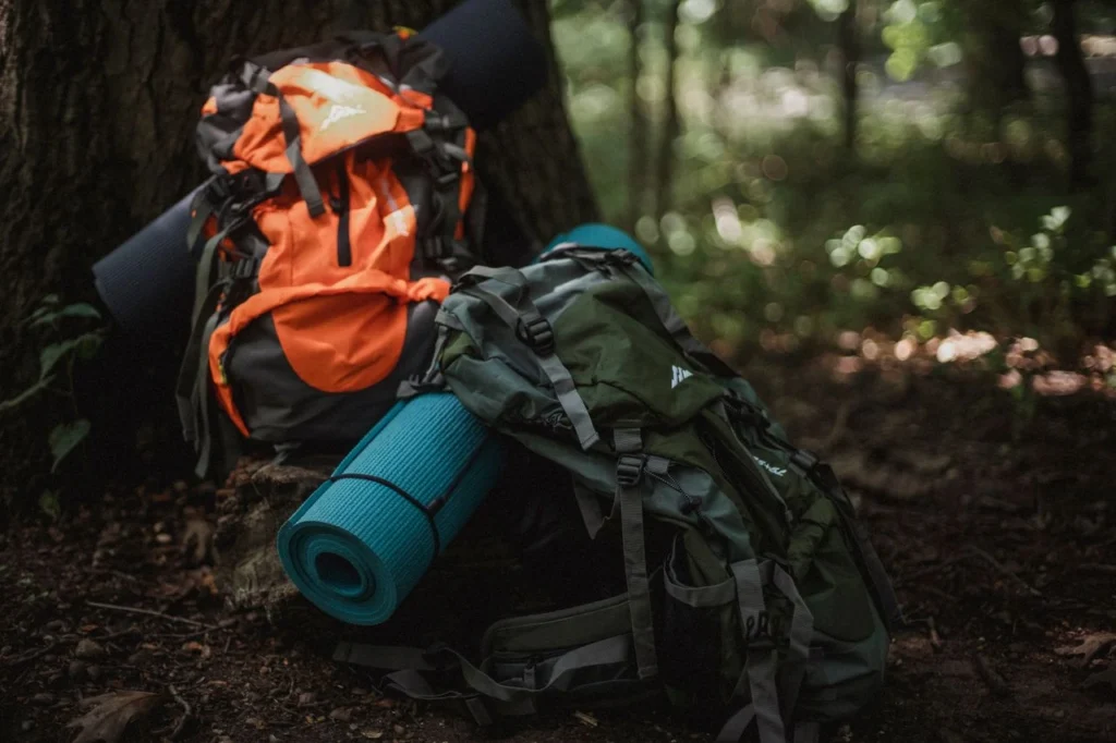 Expensive outdoor hiking equipment and backpacks packed for travel in a forest setting