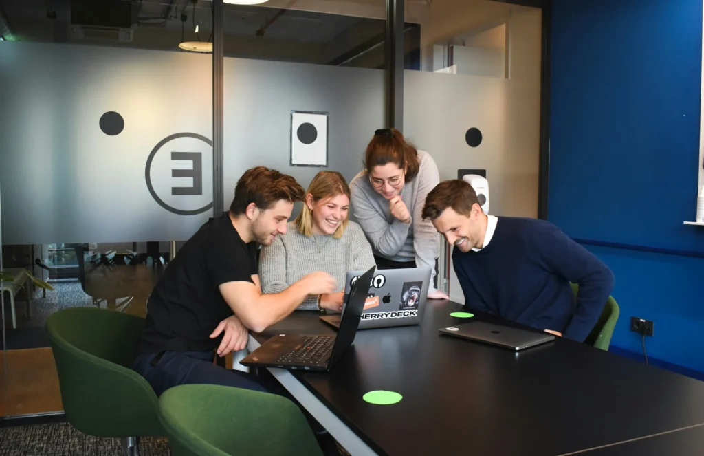 External development team collaborating on software projects with laptops in an office