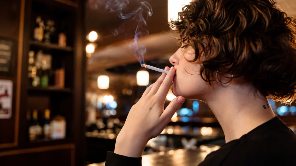 Adult smoker holding a cigarette while considering cigarette strength and switching brands